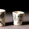Saki cups; white glaze with black underglaze.